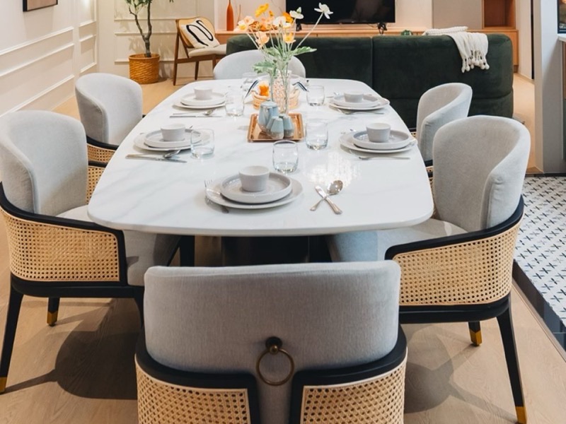 Malaysian dining room with rattan-backed chairs, a marble dining table and warm neutral walls